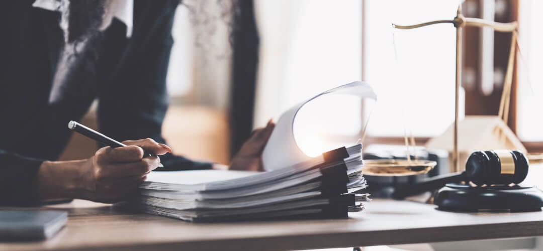 Woman with pen looking through legal documents